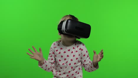 child girl using vr app helmet to play simulation game. watching virtual reality 3d video