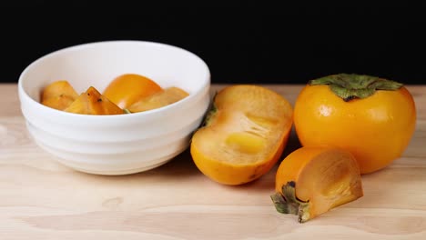 sliced persimmons arranged in a white bowl