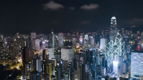 a stunning view of hong kong's skyline at night showcases illuminated skyscrapers and a vibrant city. the scene captures the energy of the urban landscape against a dark sky.