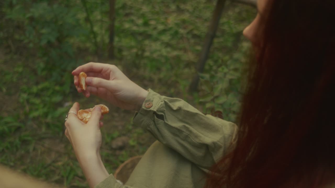 Woman Eating an Orange in a Garden