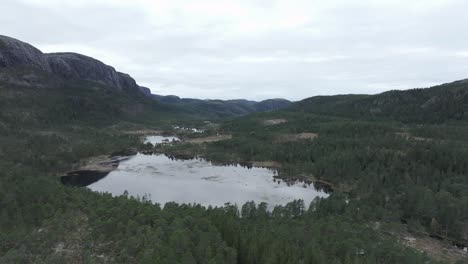 hildremsvatnet, condado de trondelag, noruega - una vista de un lago rodeado de vegetación con una cordillera en el fondo - panorámica aérea