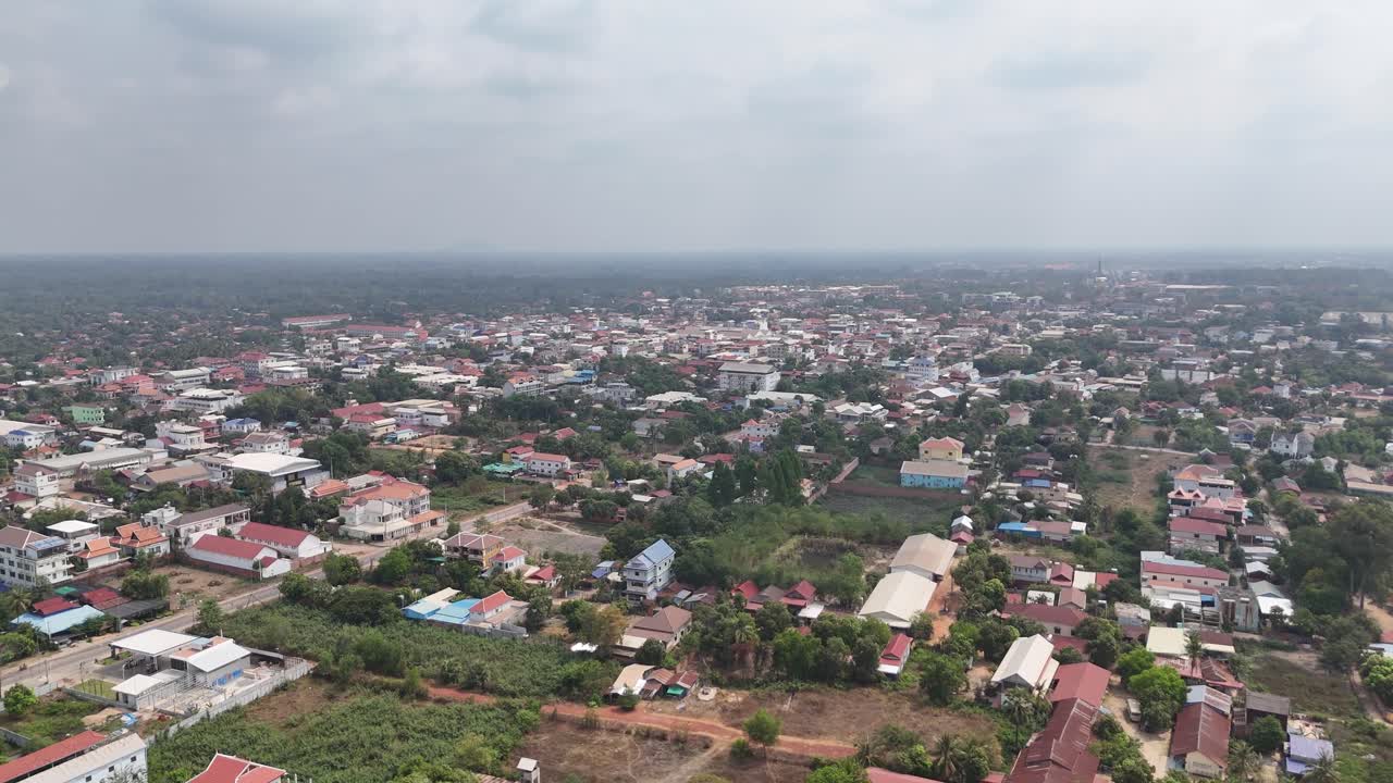 This elevated perspective captures a townscape in close proximity to Angkor Wat, Cambodia. The scene is characterized by a mix of low to medium-rise buildings