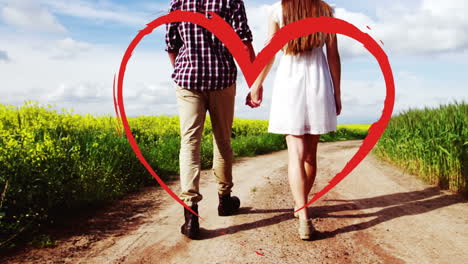 pareja caminando por el campo mientras se toman de las manos para el día de san valentín