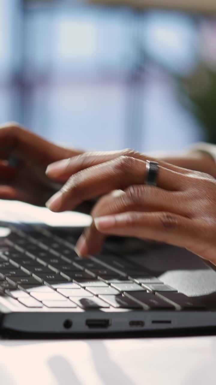 Vertikales Video: Freelancer tippt im Homeoffice auf Laptop-Tastatur, Nahaufnahme.