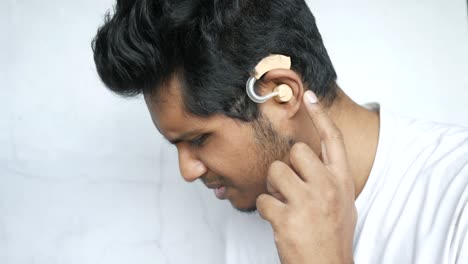 man adjusting hearing aid