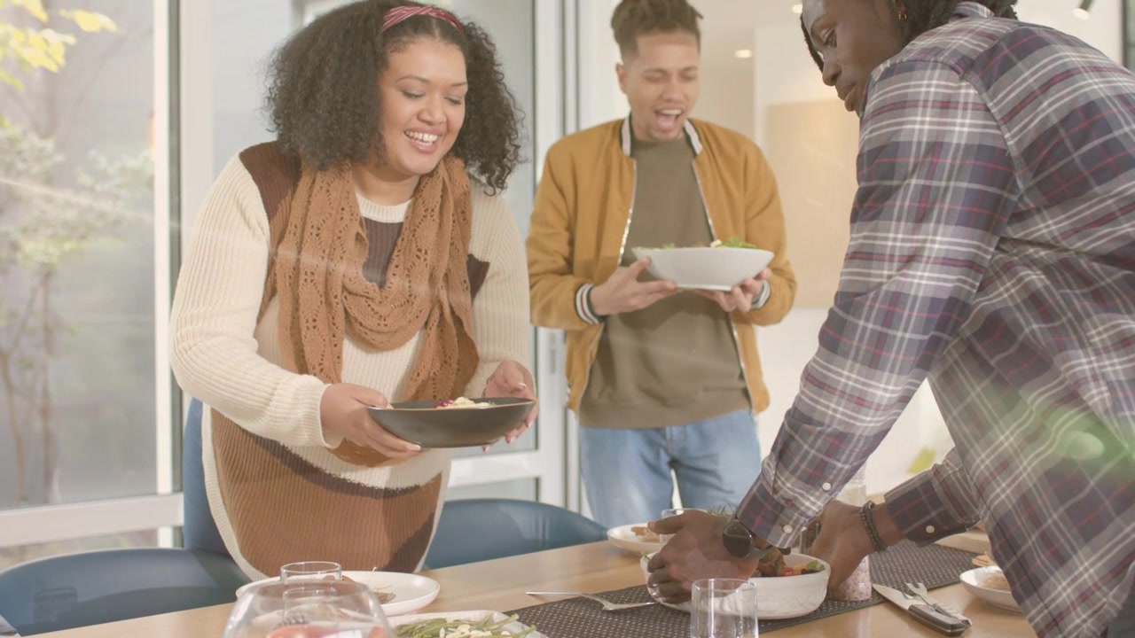 Three friends arriving placing bowls and serving shared meal at table animated tags following hands