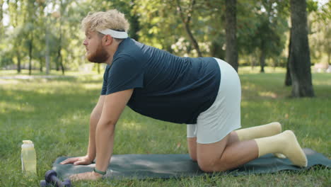 obese man practicing yoga in park