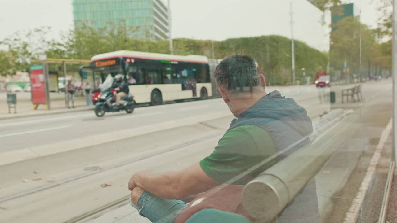 Homem sentado no ponto de ônibus