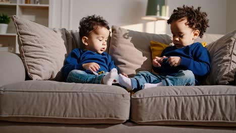 two boys playing together on a couch