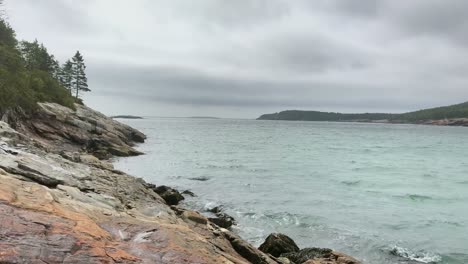 4k-Wind-blows-through-woman's-hair-as-she-looks-over-Maine-Coastline