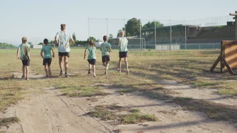 Grupo-De-Niños-Caucásicos-Entrenando-En-El-Campo-De-Entrenamiento