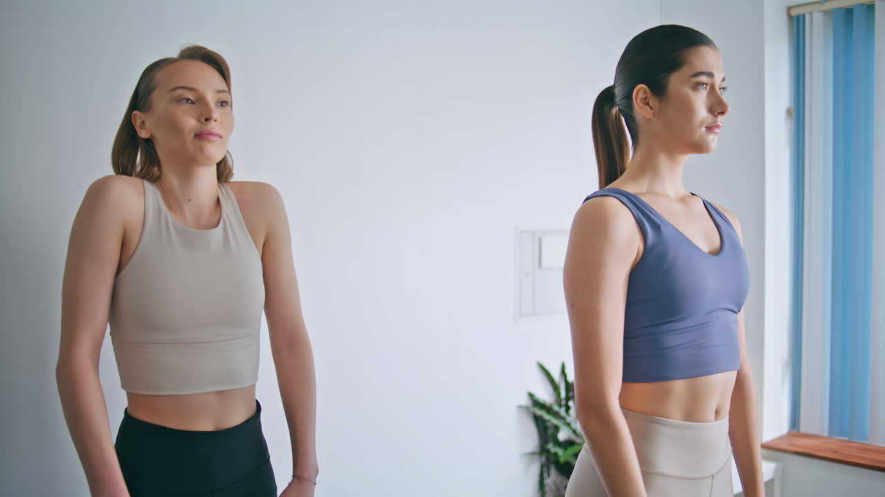 Yogi women warming shoulders up training at home. Ladies morning yoga exercises