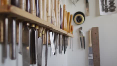 multiple woodworking tools hanged on a stand in a carpentry shop