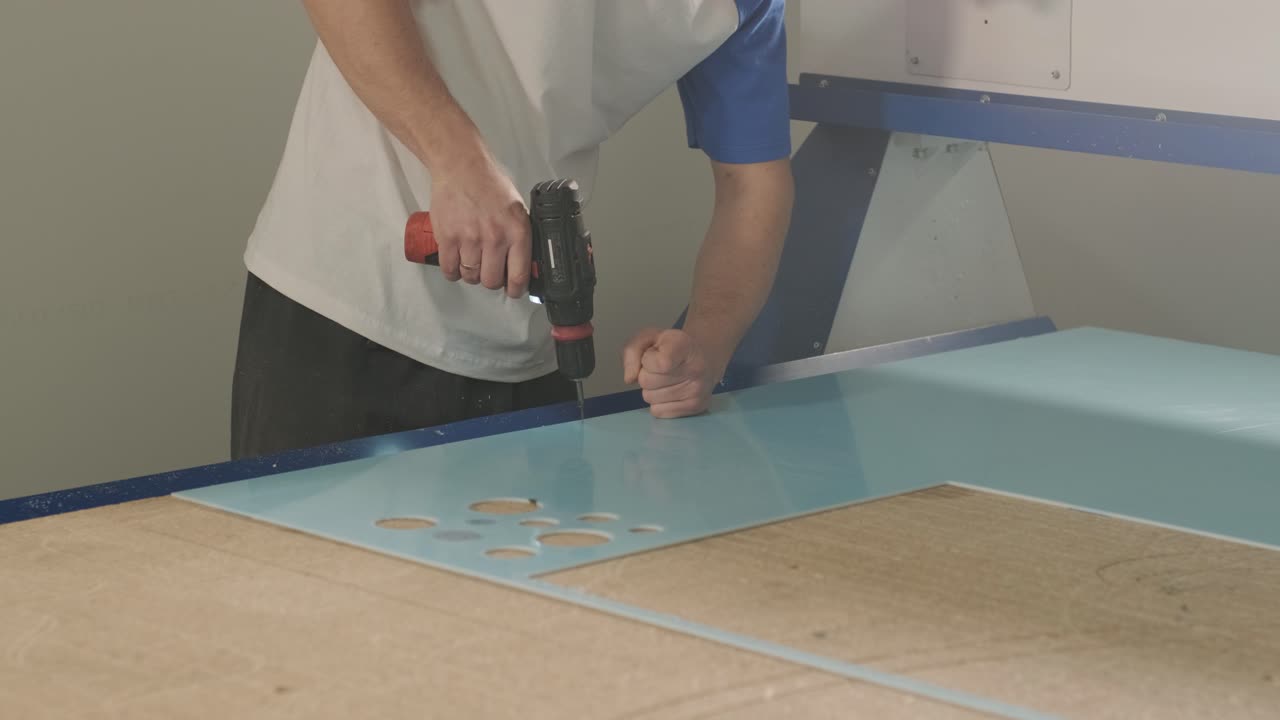 producción de carteles publicitarios en la fábrica. destornillador aprieta el tornillo