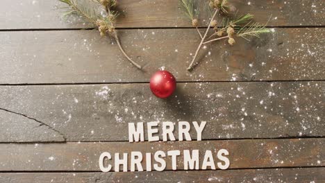 video of christmas greetings text and decoration on wooden background