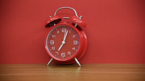 reloj despertador rojo en la mesa de madera