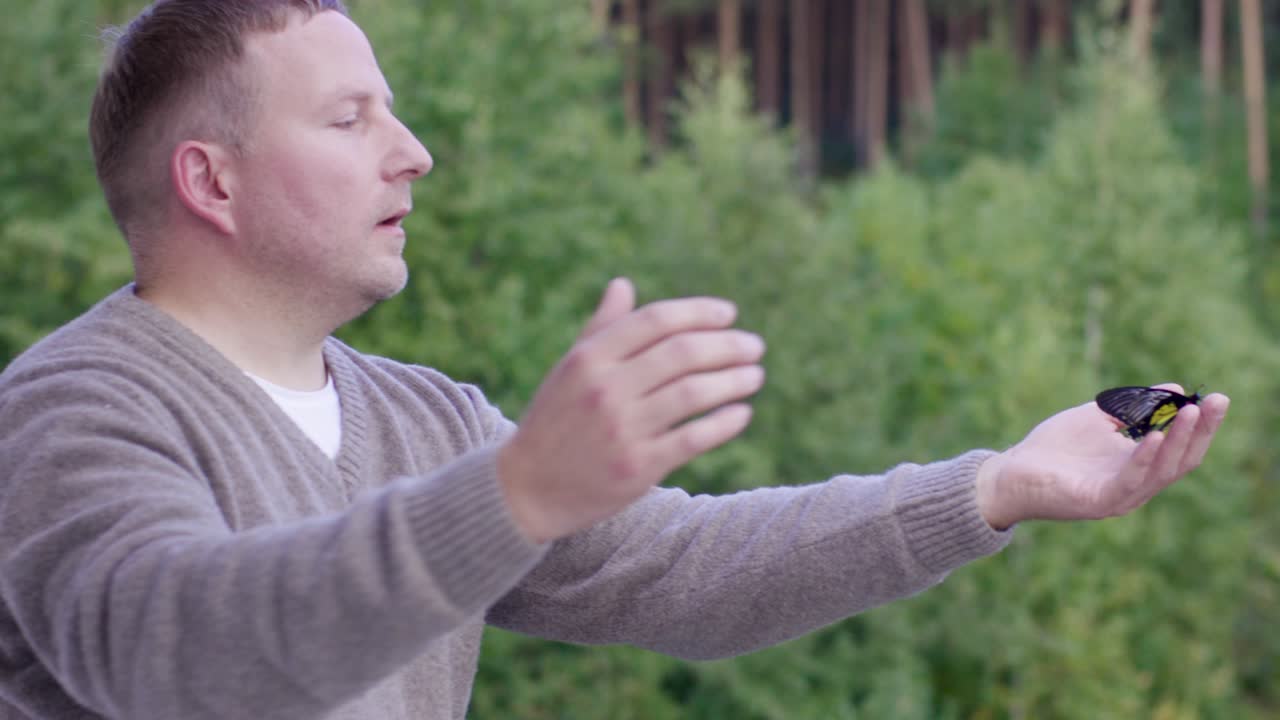 숲에서 나비를 들고 있는 남자