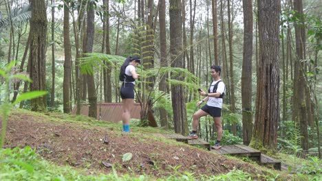 asian couple taking photos during outdoor adventure in forest