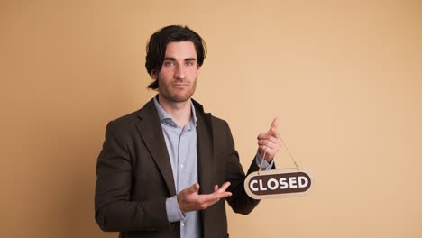 upset businessman with closed sign in brown studio