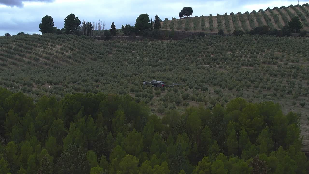 Drone in flight over forest with position lights and signal flashes. Drone in flight rotating over forest. Close aerial view in orbit.