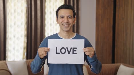 happy indian man holding love banner