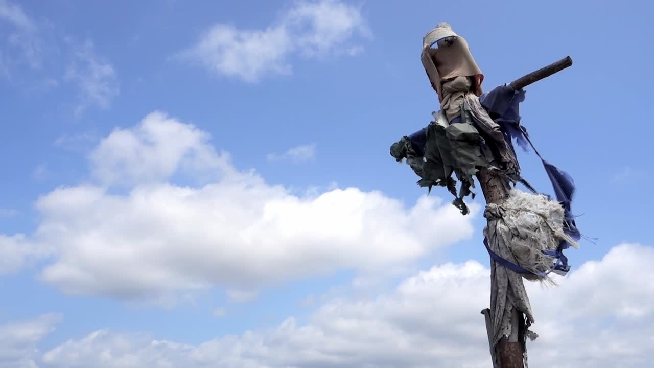 espantapájaros hecho con trapos y un cubo y el cielo