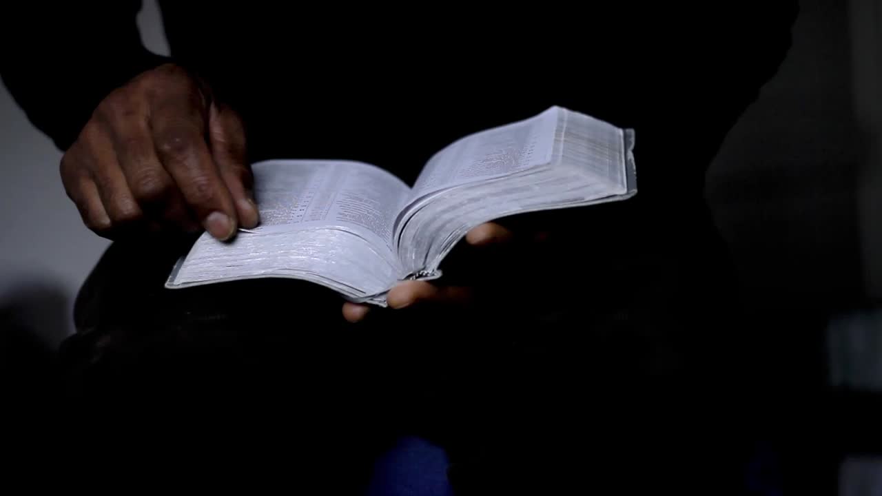 man praying with bible with black background with people stock video stock footage