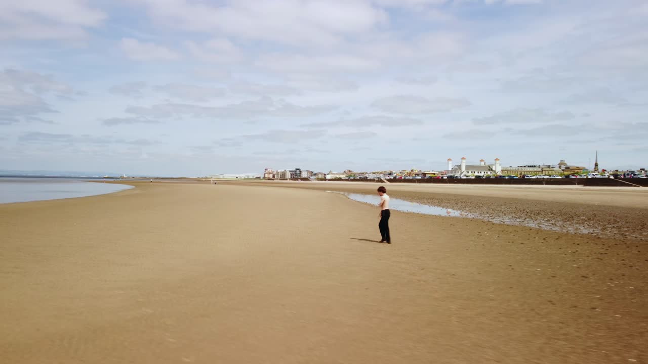 해변에서 셔츠나 신발이 없는 젊은 남자의  ⁇ 도 항공 영상