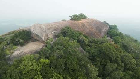 aerial forward view over sigiriya pidurangala rock on a foggy sunrise