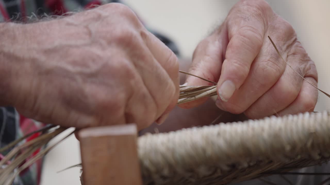 vista de cerca sobre la técnica de tejido de sillas durante el trabajo con una mano de hombre, italia.
