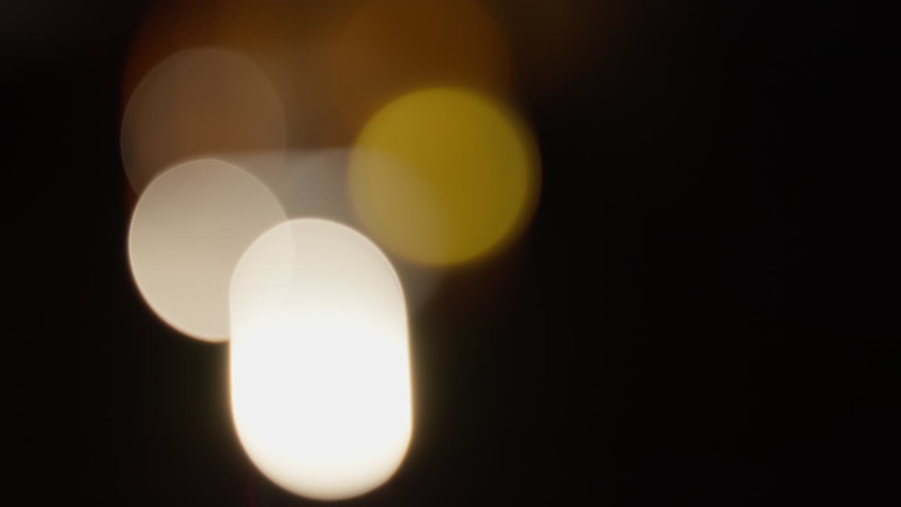 Abstract slow motion video of bokeh spheres in warm hues, softly glowing with an ethereal atmosphere. The blurred edges and gentle light play evoke a dreamy, surreal effect perfect for textures.
