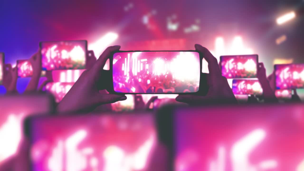 los fanáticos están grabando videos en teléfonos inteligentes. muchos teléfonos inteligentes