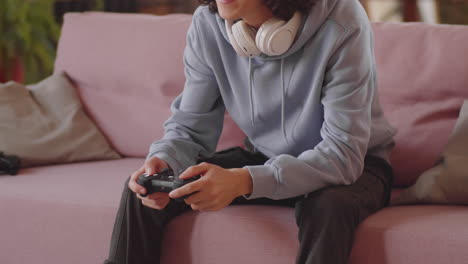 boy sitting on sofa and playing video game