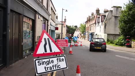 cars navigate single file traffic in town