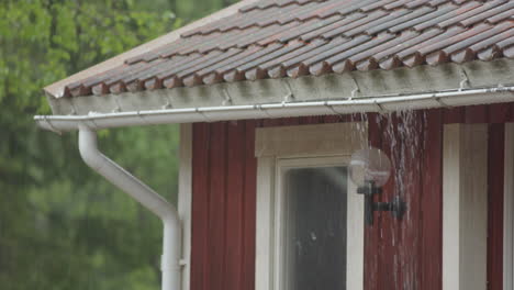 closeup - heavy rain on the roof causes the gutter to overflow