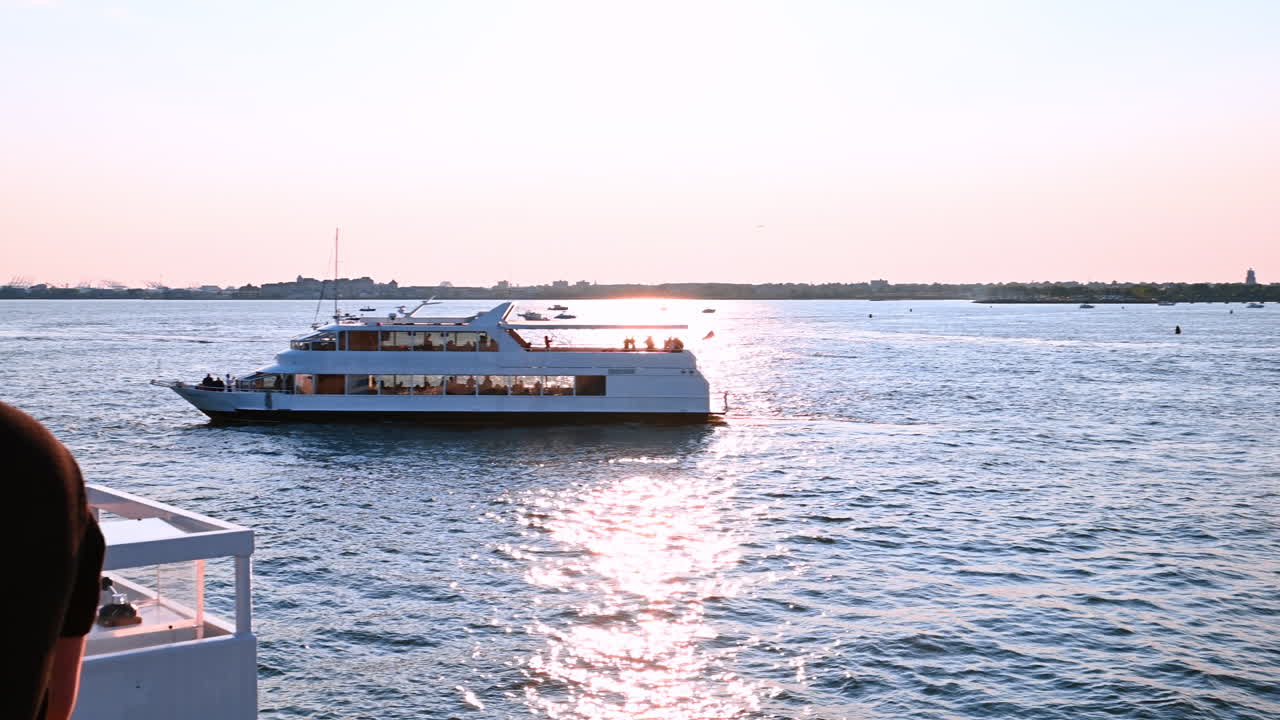 Krydstogtbåd med folk, der rejser langs floden ved solnedgang. Tur på Hudsonfloden rundt i New York, USA