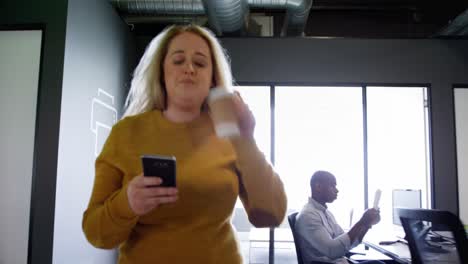 mujer de negocios usando teléfono móvil en la oficina 4k