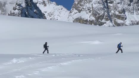 people skiing in deep snow high in the alps of tyrol, bright, winter day in austria - static shot