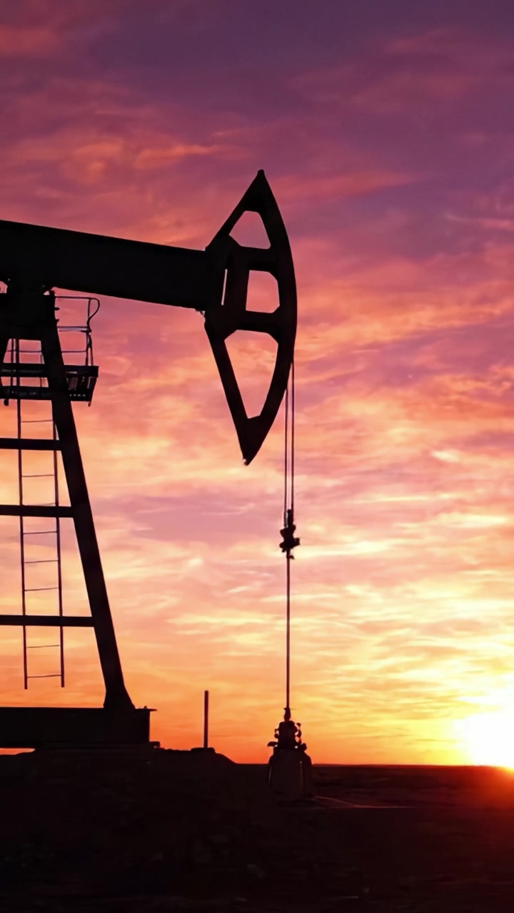 Silhouette of an Oil Pump Jack Against a Colorful Sunset Sky, Symbolizing the Energy Industry and the Natural Resources of Our Planet