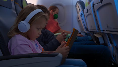 Madre-Dormida-Y-Niños-Con-Aparatos-Viajando-En-Avión.