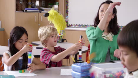 teacher sits with young kids using blocks, shot on r3d