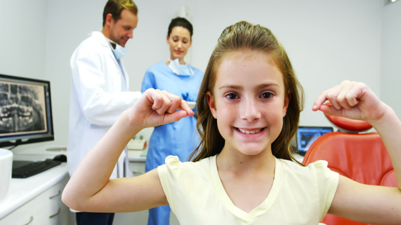 улыбающаяся девушка делает жест рукой, чтобы показать зубы.