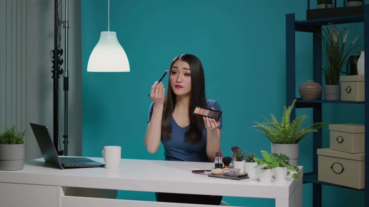 Female blogger doing makeup review with eyeshadow palette