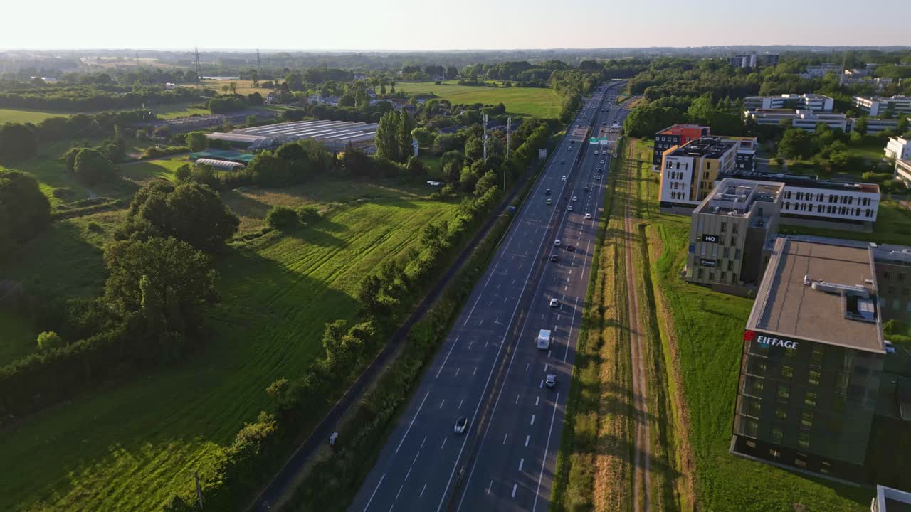 Highway crossing suburb of Rennes, France. Aerial drone forward