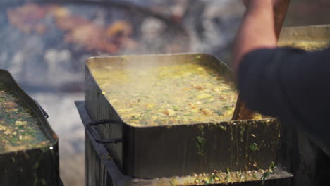 rectangular cauldrons full of stirred typical argentine locro stew, slow motion