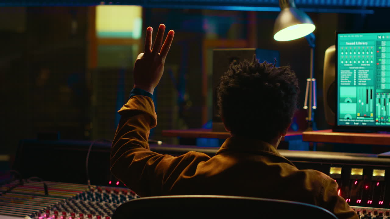 African american audio engineer counting down singer in sound booth