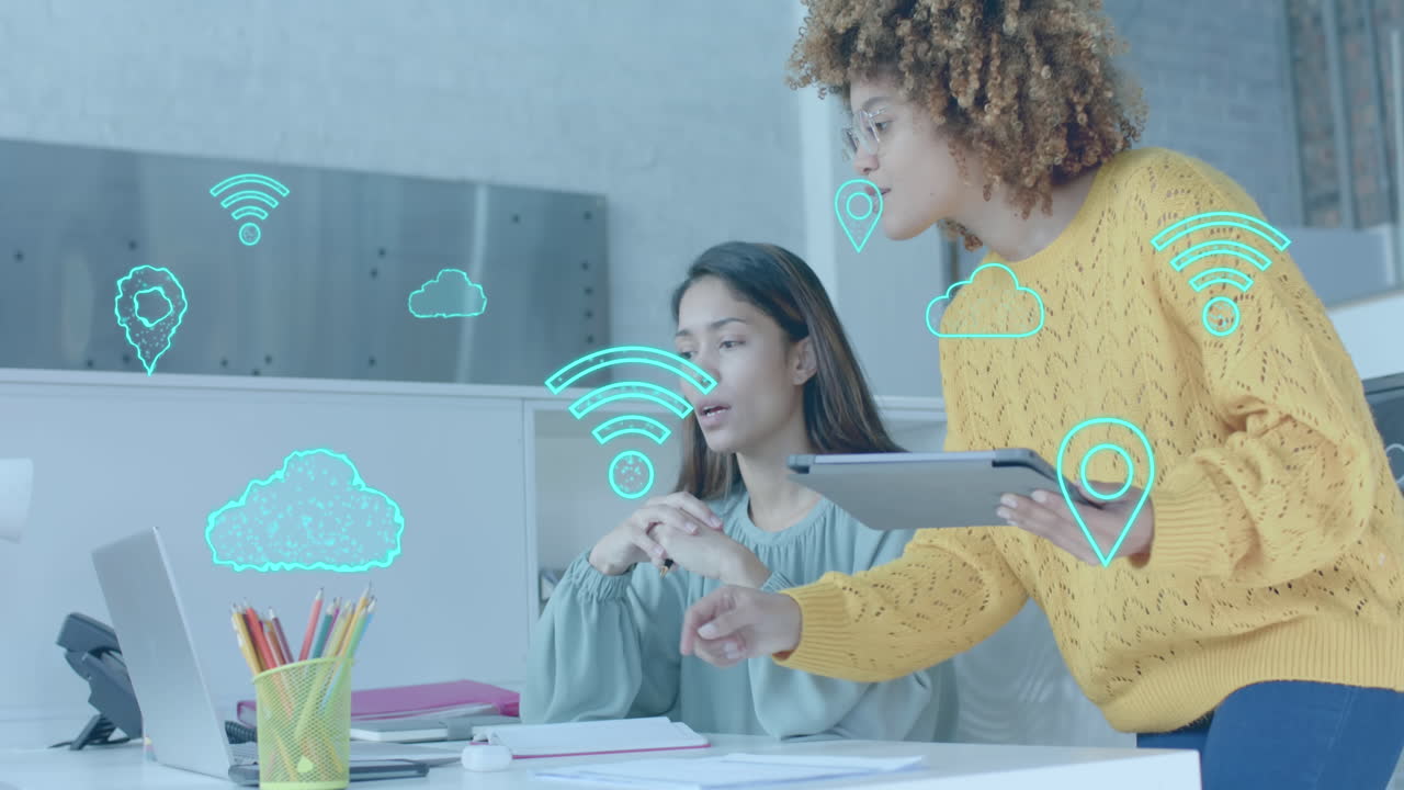 iconos de wi-fi, nube y gps sobre diversas colegas mujeres en discusión en una computadora portátil en una oficina casual
