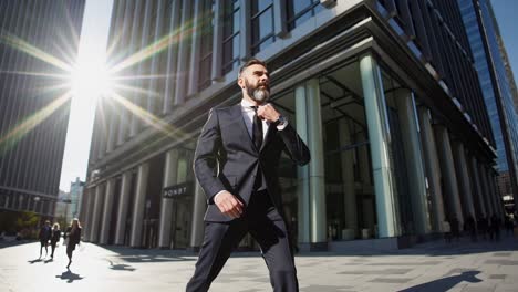 un hombre de negocios caminando por una ciudad moderna.
