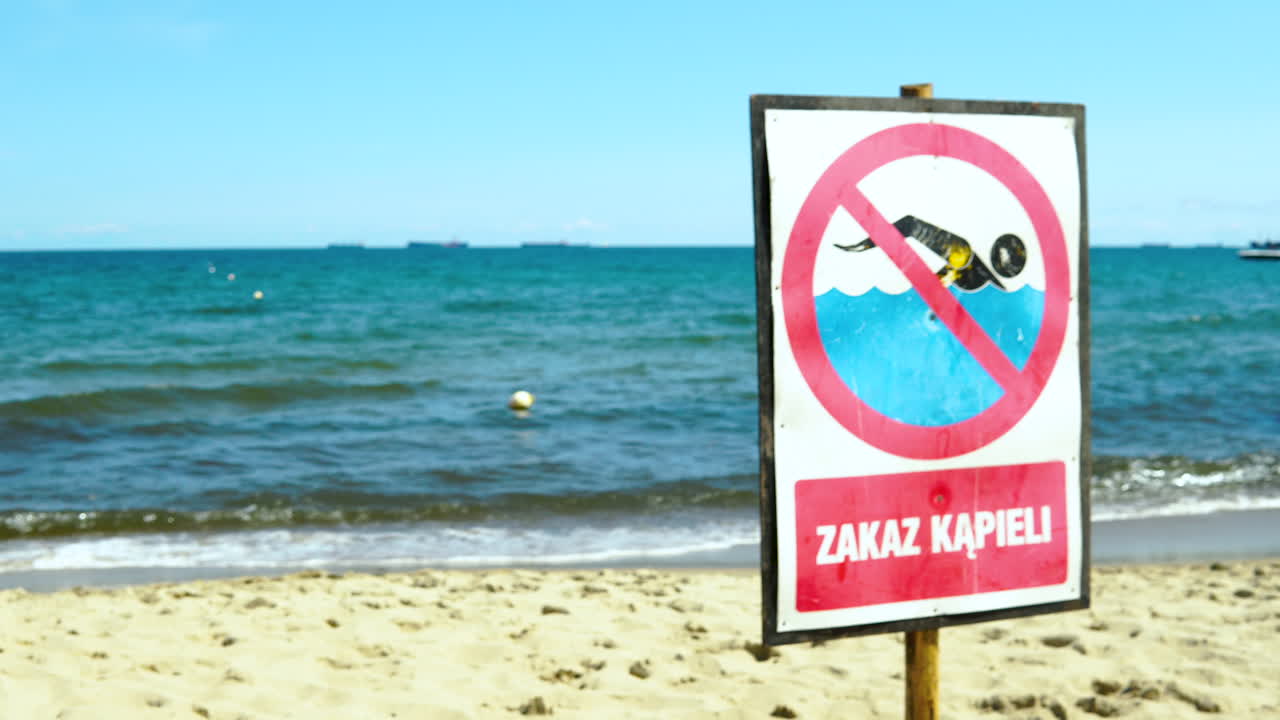 The board prohibits swimming on the seaside beach, no swimming today on sea, information board for tourists