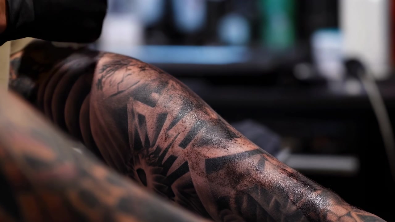 Tattoo Artist Cleaning Fresh Tattooed Arm With Gauze, Black Gloved Hand Wiping Inked Sleeve In Sterile Studio,
